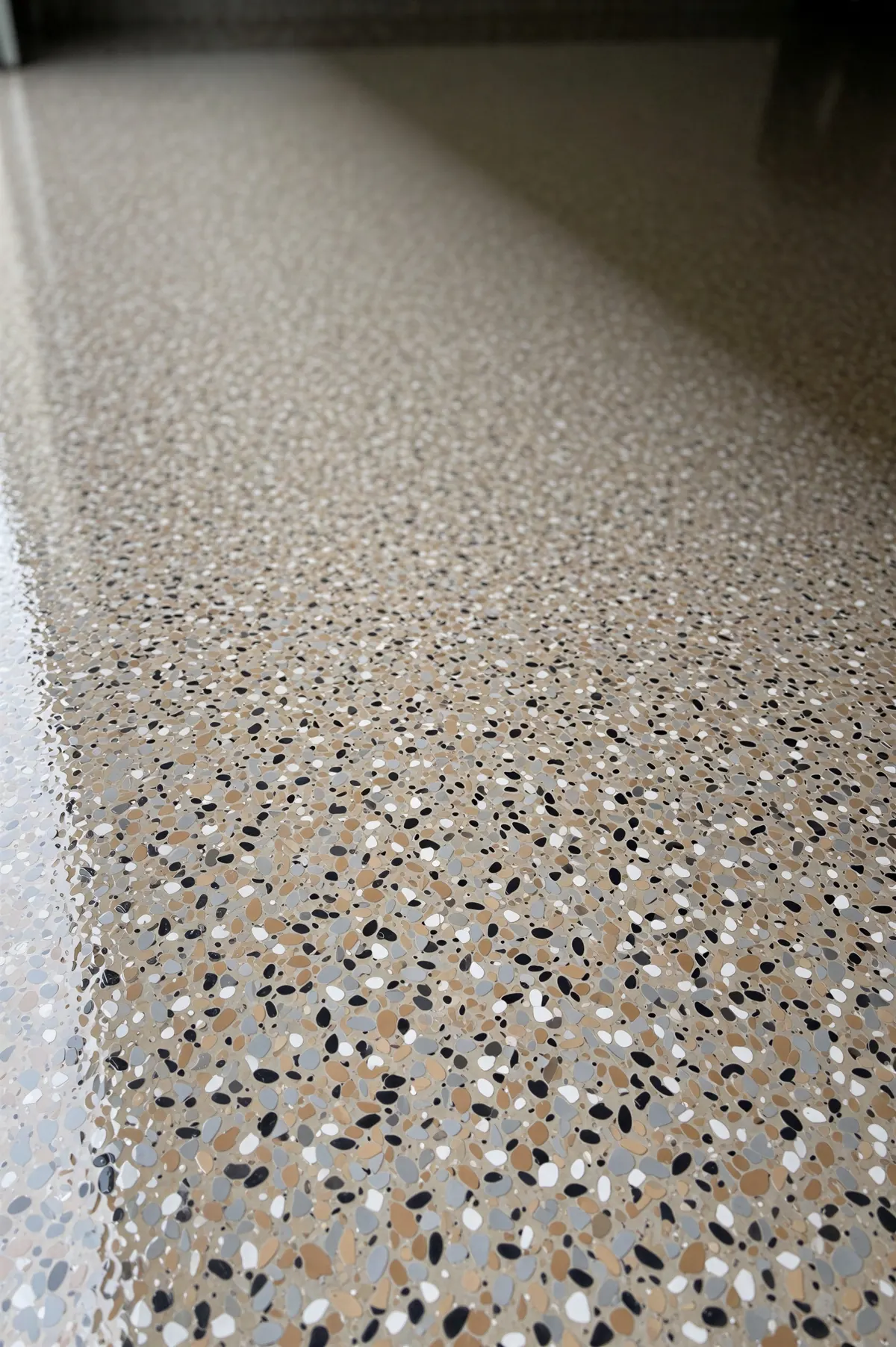 Two decorative flake floor samples, one black with white, gray and tan chips and one light gray with mixed chips