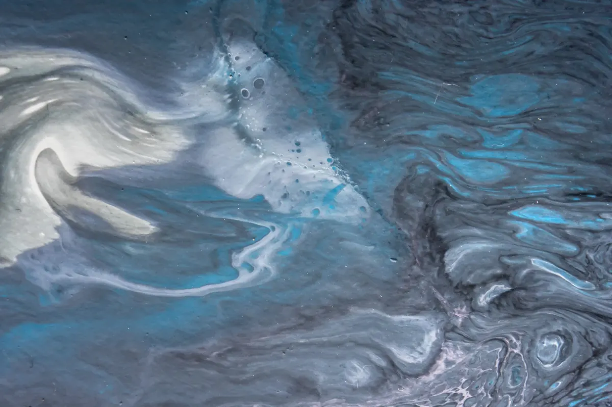 Close-up of a metallic epoxy floor with swirling blue, silver and charcoal pigments
